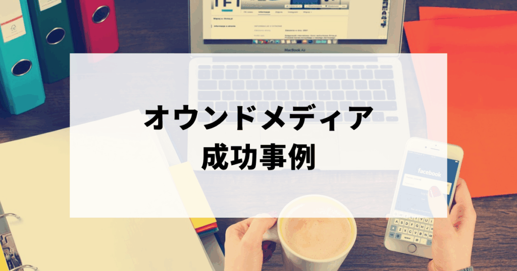 コーヒーと携帯を持ってパソコン作業をする女性