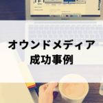 コーヒーと携帯を持ってパソコン作業をする女性